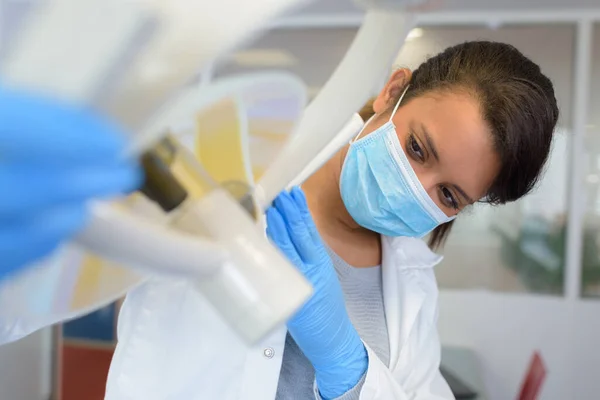 Dentista Feminino Usando Máscara Cirúrgica Enquanto Segurando Lâmpada Dentária — Fotografia de Stock
