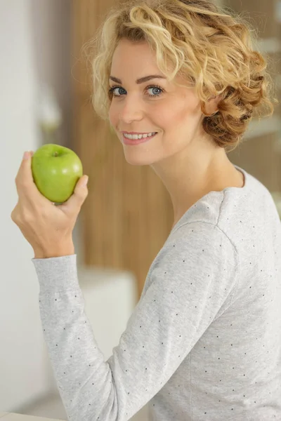 年轻快乐的微笑的女人 室内有绿色的苹果 — 图库照片