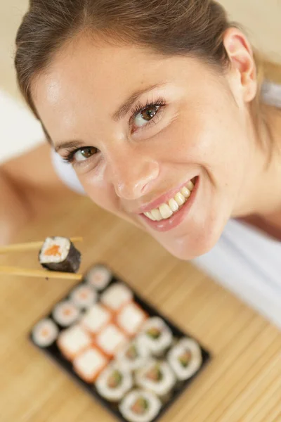 Suşi Sarmalarında Yemek Çubuğunda Mutlu Bir Kadın — Stok fotoğraf