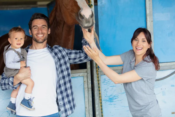 馬の農場で赤ちゃんと幸せなカップル — ストック写真