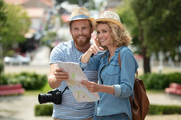 市内地図を使って休暇中の美しいカップルは — ストック写真