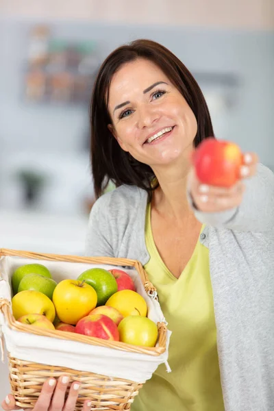 Młoda Kobieta Jeść Świeże Czerwone Jabłko Wewnątrz Domu Kuchnia — Zdjęcie stockowe