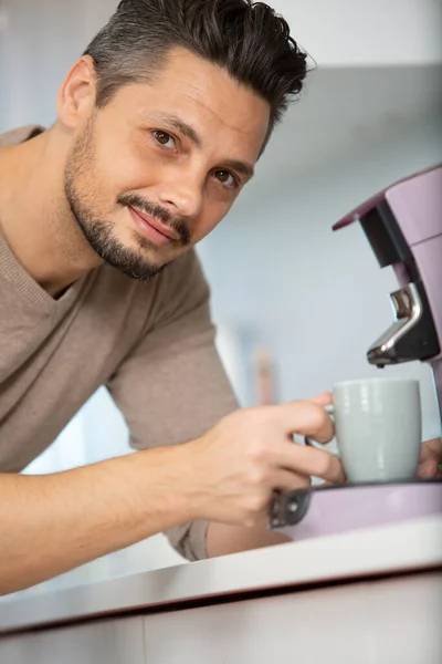 若い男性のバリスタがコーヒーを作っていて — ストック写真