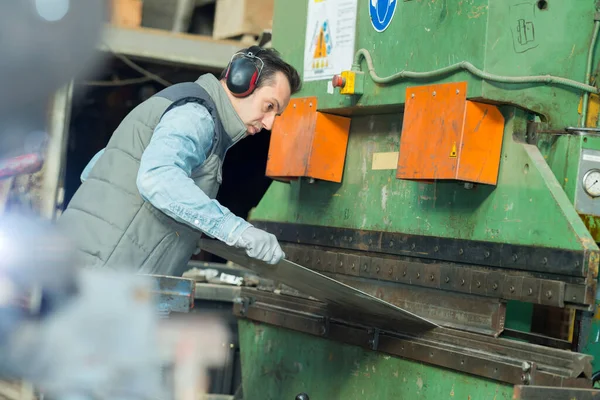 Endüstriyel Metal Işçisi Makineye Malzeme Yerleştiriyor — Stok fotoğraf