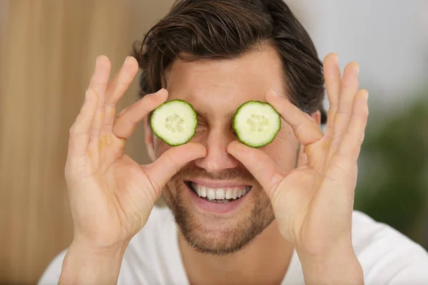 Man Putting Sliced Cucumber His Eyes — Stock Photo, Image