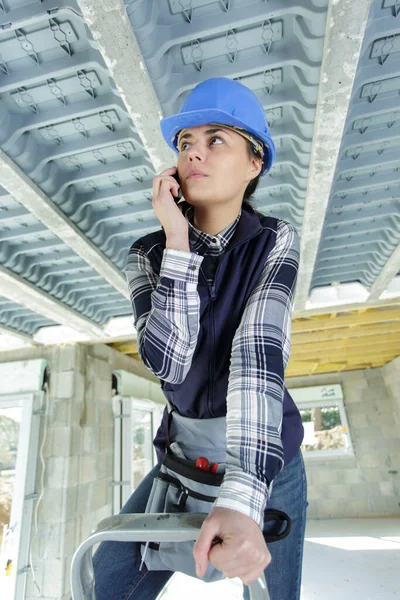 女建筑工人在梯子上打电话 — 图库照片