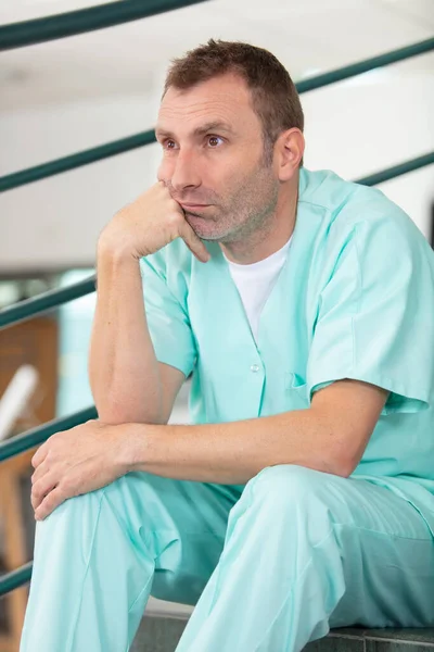 Depresja Mężczyzna Pielęgniarka Siedzi Sam Schodach — Zdjęcie stockowe