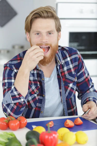 Αθλητικός Άνθρωπος Τρώει Ντομάτες Στο Σπίτι — Φωτογραφία Αρχείου