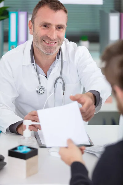 オフィスでの医師との協議を持つ男性患者 — ストック写真