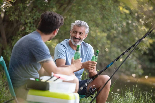 湖で釣りやビールを飲む男性の友人は — ストック写真