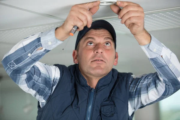 Bir Elektrikçi Tavan Lambasını Tamir Ediyor — Stok fotoğraf
