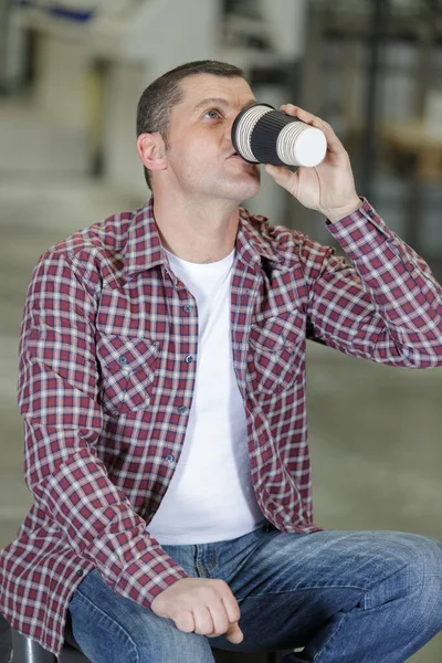Εργαζόμενος Πίνοντας Καφέ Και Ανάπαυσης Κάθεται Στο Εργοστάσιο — Φωτογραφία Αρχείου