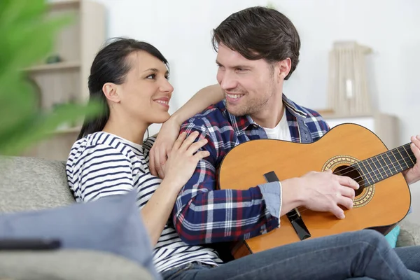 Couple Blotti Sur Canapé Pendant Que Homme Joue Guitare — Photo