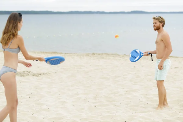 Νεαρό Ζευγάρι Που Παίζει Τένις Στην Παραλία — Φωτογραφία Αρχείου