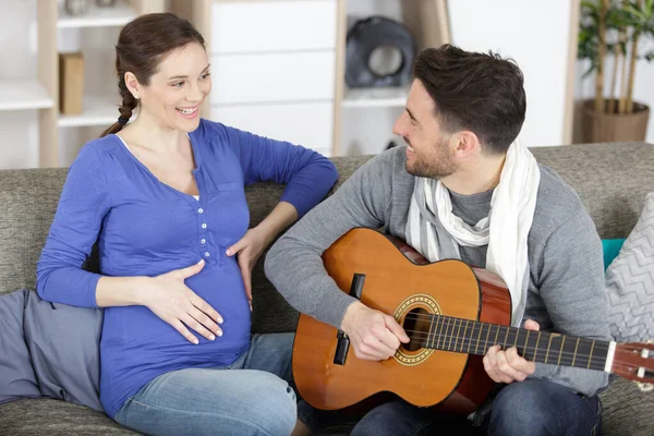 Kocası Güzel Hamile Karısı Için Gitar Çalıyor — Stok fotoğraf