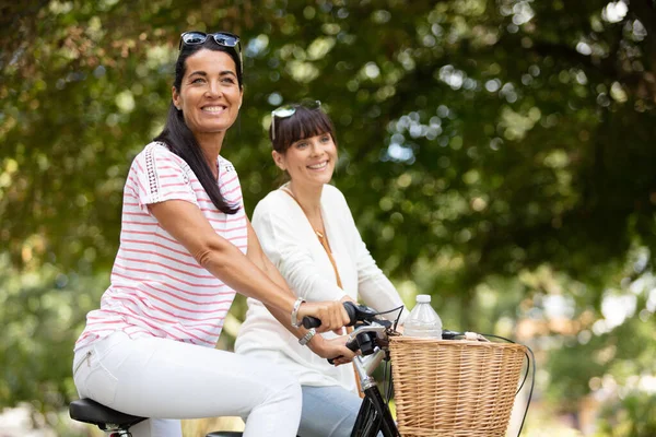 Duas Senhoras Morena Atraente Ciclismo Juntos — Fotografia de Stock