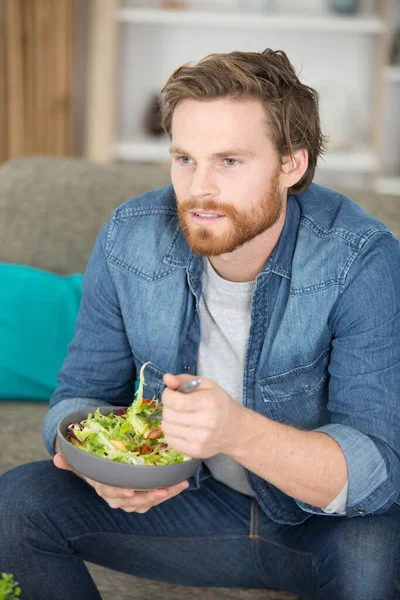 一个男人在他的公寓里吃沙拉的肖像 — 图库照片
