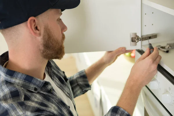 Man Posing While Fixing Cupboard Hinges — Stock Photo, Image