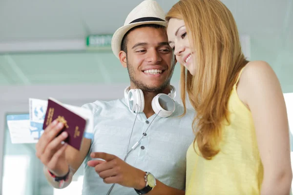 stock image young couple at airport holding passports and boarding cards