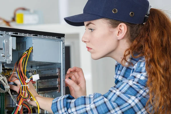 職場でコンピューターを修理している若い女性は — ストック写真