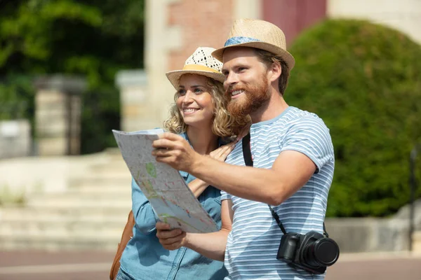 旅行的夫妇在地图上搜寻下一个目的地 — 图库照片