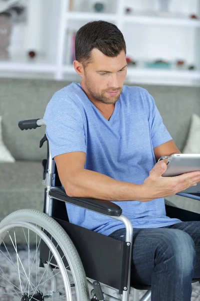 タブレットコンピュータを搭載した車椅子の若いビジネスマンは — ストック写真
