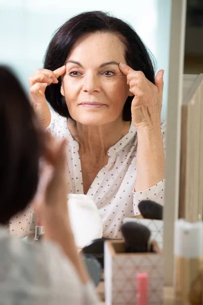 Olgun Bir Kadın Aynada Kırışıklıklarını Kontrol Ediyor — Stok fotoğraf