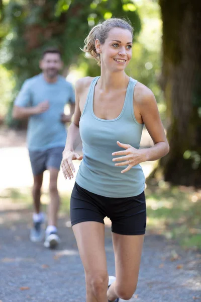 幸せなカップルが走りジョギングをしながら — ストック写真