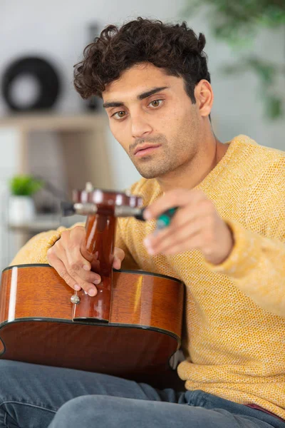 Male Musician Tuning Acoustic Guitar — Stock Photo, Image