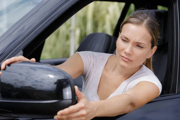 여자가 자동차 거울을 조정하는 — 스톡 사진