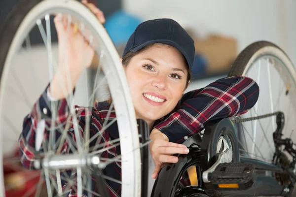 可爱的高加索女工手握和修理自行车轮 — 图库照片