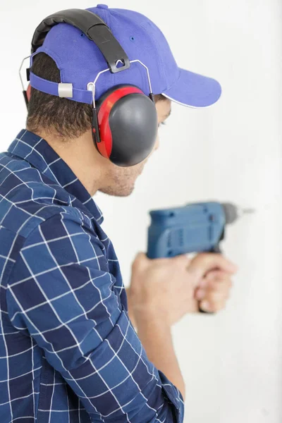 a man drills a wall with a drill