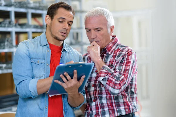 Two Men Contemplating Issue Looking Clipboard — Stock Photo, Image