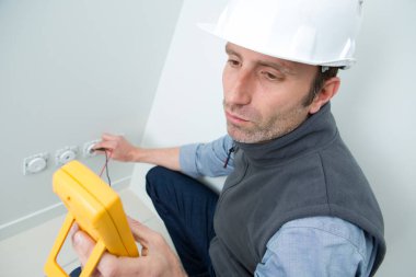 man working on electrical wall socket clipart