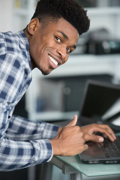 笑的年轻人使用的便携式计算机 — 图库照片