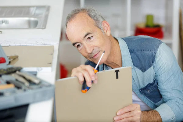 Senior Man Assembling Kitchen Cupboard — Stock Photo, Image