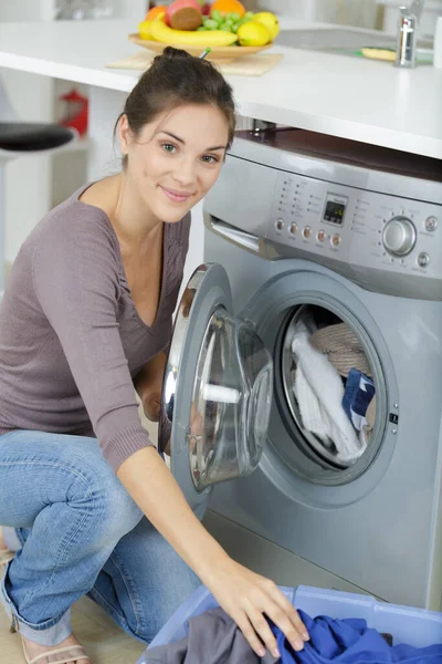 在洗衣机里装脏衣服的妇女手 — 图库照片