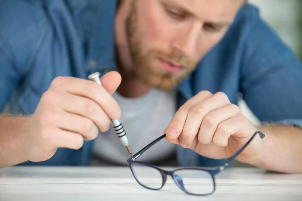 Junger Mann Fixiert Brille Mit Biegezange — Stockfoto