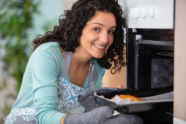 在明亮的厨房里拿着烤盘的随意快乐女人 — 图库照片