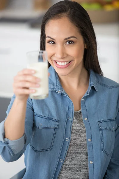 美しいミルクのグラスを持った家庭用キッチンの中年女性 — ストック写真