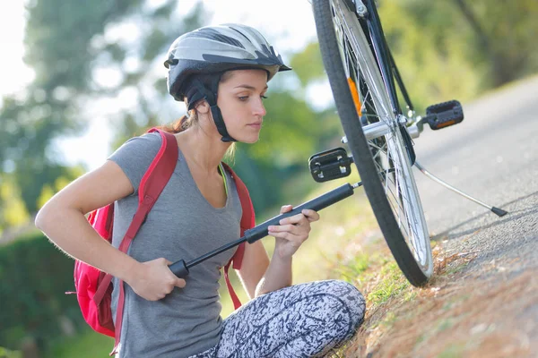 若い女性が自転車用ポンプでタイヤを汲み上げ — ストック写真