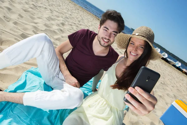 Hermosa Joven Pareja Sentado Playa Haciendo Selfie —  Fotos de Stock