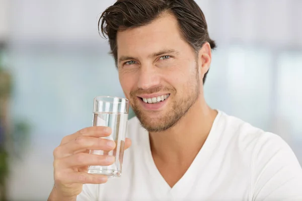 快乐的男人 拿着一杯水 对着相机微笑 — 图库照片