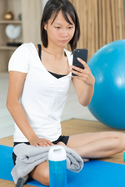 Γυναίκα Κοιτάζοντας Smartphone Κατά Διάρκεια Της Άσκησης Ρουτίνας — Φωτογραφία Αρχείου