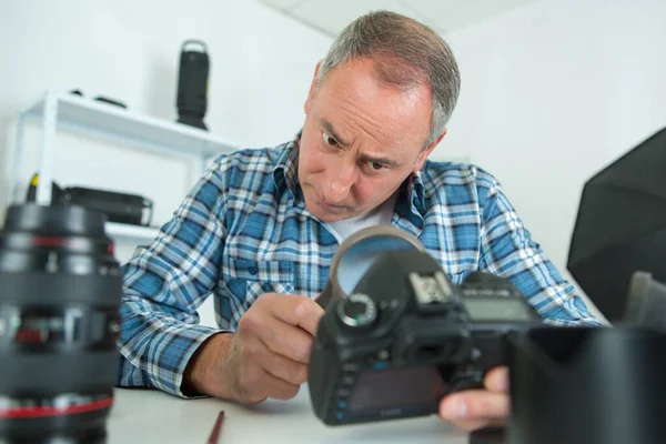 Man Inspecting Camera Lenses — Stock Photo, Image