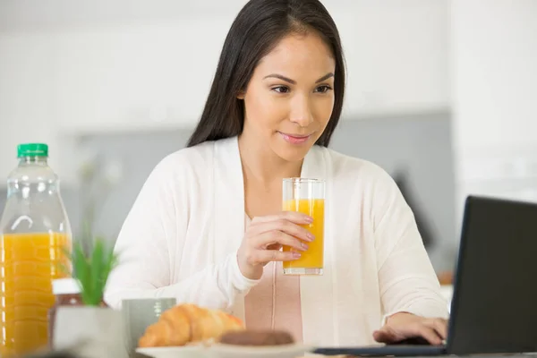 Donna Positiva Con Succo Frutta Utilizzando Computer Portatile Cucina — Foto Stock