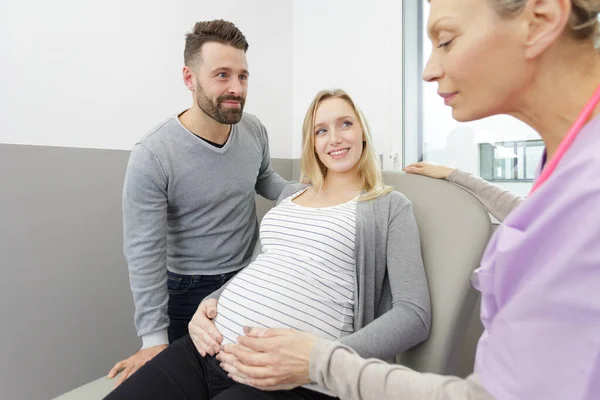 妊娠中の女性と彼女の夫はクリニックで医師を訪問 — ストック写真