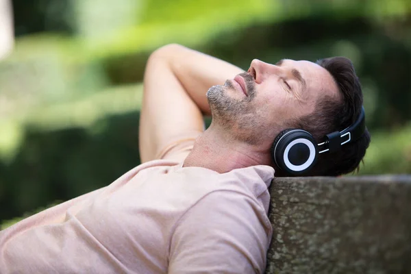 Man Buiten Ontspannen Terug Tijdens Het Luisteren Naar Hoofdtelefoon — Stockfoto