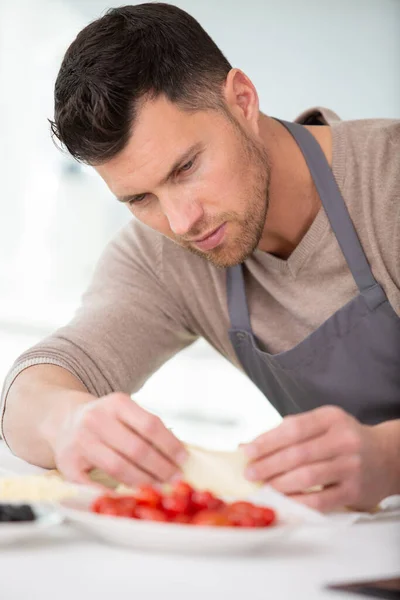 Mann Löffelt Tomatensauce Auf Pizzaboden — Stockfoto