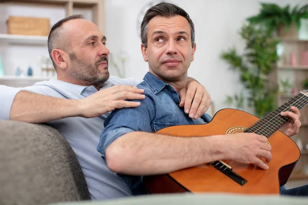 Medelålders Homosexuella Par Med Gitarr Hemma — Stockfoto